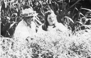 ACROSS GENERATIONS - Marie works with her granddaughter, Amy Mills, to gather minute kika(cigar flower) blossoms for leis.  Amy--who is preficient at making this tedious but beautiful lei--and her family live with Marie and Bill...three generations caring for the farm and passing on the knowledge and skills of the master lei-maker.